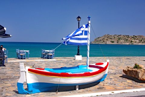 Boot mit griechischer Flagge am Meer