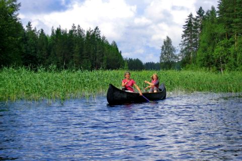 Damen paddeln im Kanu auf der Finnischen Seenplatte