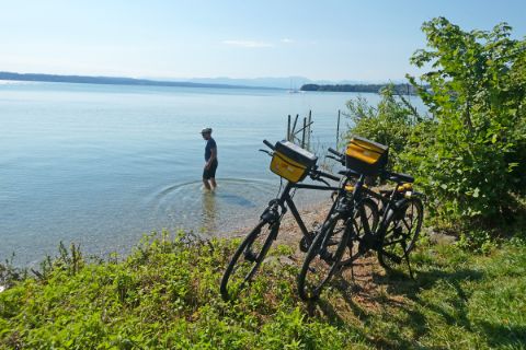 Radfahrer kühlt sich im See ab 