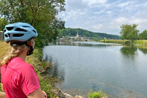 Radfahrerin am Ufer blickt aufs Wasser der Loire