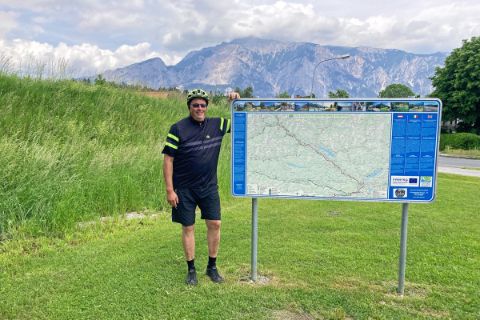 Herr Hieke vor der Karte des Alpe-Adria-Radwegs