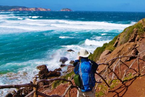 Wanderer mit Panoramablick aufs Meer auf Menorca