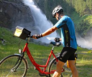 Cyclist in front of the waterfalls in Krimml