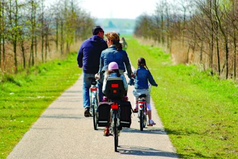 Familie am Radweg in Holland mit Kinderanhänger