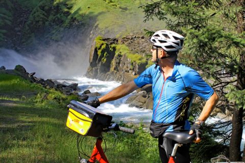 Cyclist in front of waterfalls in Krimml