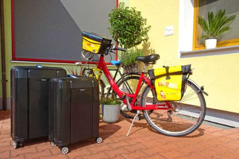 Fahrrad und Gepäck vor Hausmauer