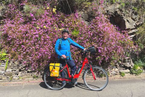 Cyclist in front of a flowering bush