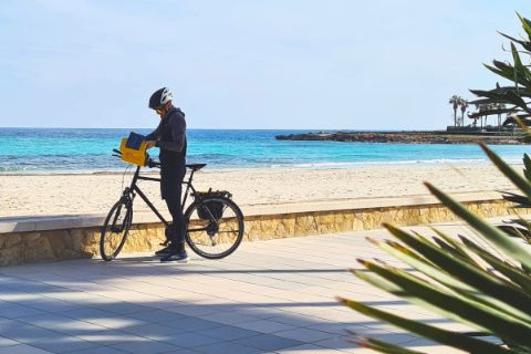 Cyclist with bike in front of the sea