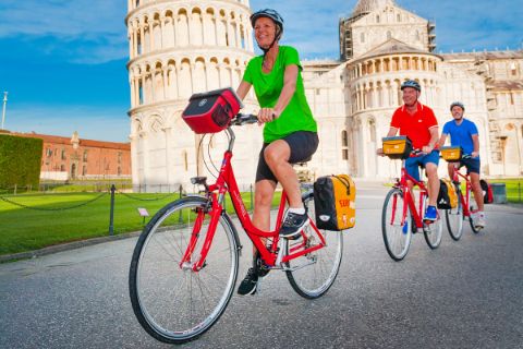Cyclists in front of the leaning tower of Pisa
