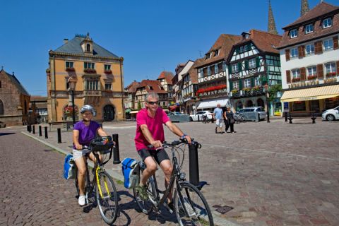 Radfahrer radeln durch ein typische Kleinstadt im Elsass