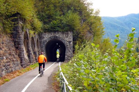 Cyclists biking into a tunnel
