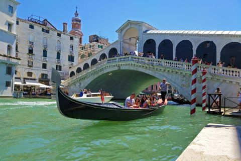 Rialto Brücke mit Gondolere in Venedig