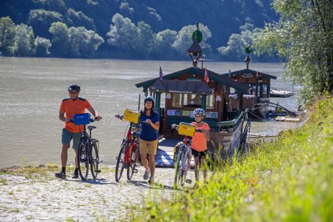 Radfahrer nach der Fahrt mit der Fähre über die Donau