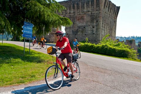 Cyclists passing the old ruin of Borghetto