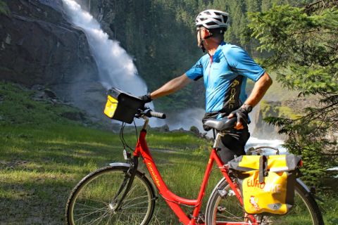 Cyclist in front of waterfalls in Krimml