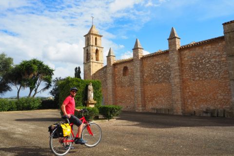 Cyclist in front of the church of Son Negre