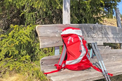 Red hiking backpack on hiking bench