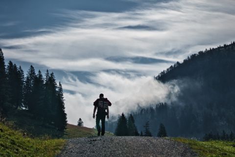 Ein Wanderer auf der Postalm mit besonderer Wolkenstimmung im Hintergrund