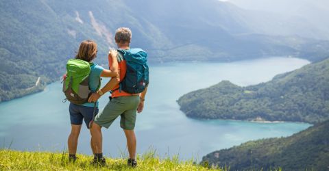 Wanderer bewundern den wunderschönen in Bergen eingebetteten Molvenosee 