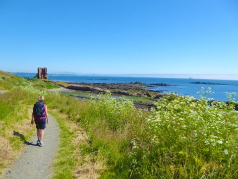 Panoramablick am Küstenwanderweg mit Wanderin