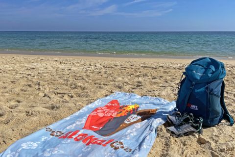 Backpack and beach towel by the sea