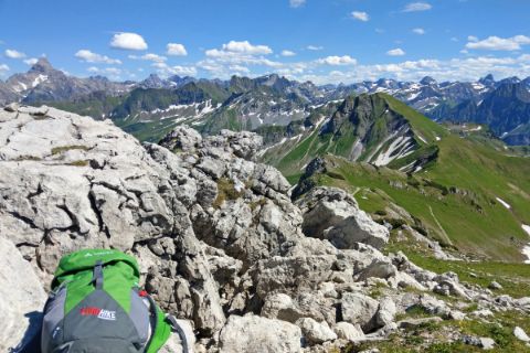 Allgäu Alps at Nebelhorn in Oberstdorf with green backpack over mountain ridge