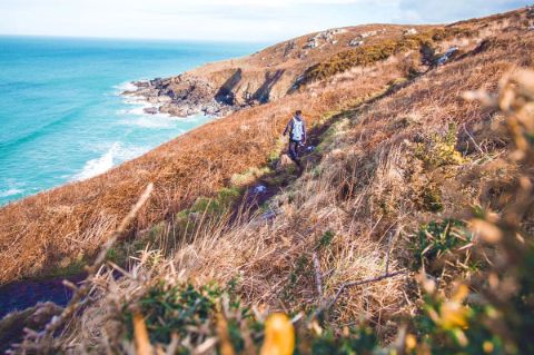 Wanderer am Küstenweg in Cornwall