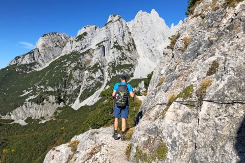 Hikers in front of rock massifs on the Dachstein