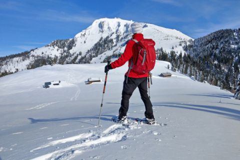 Wanderer im Winter mit Blick auf die verschneiten Gipfel
