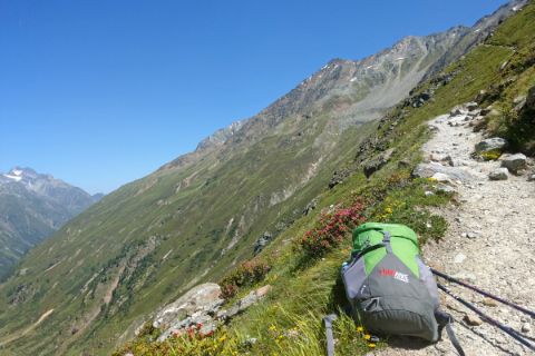Wanderpfad mit grünem Rucksack und Fernsicht
