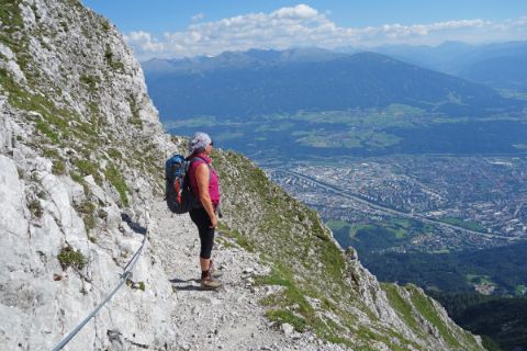 Wanderer genießt vom steinigen Wanderpfad den herrlichen Talblick hintunter nach Innsbruck