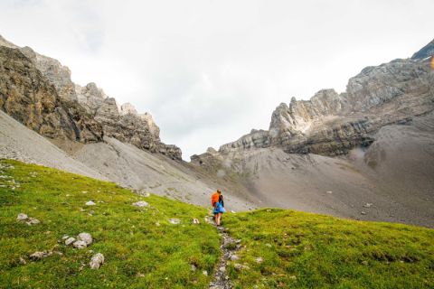 Hiker on the Swiss mountain crossing Bunderchrinde on the descent to Bonderalp
