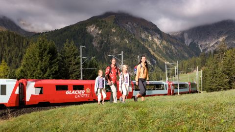 Eine Familie mit dem Glacier Express im Hintergrund. Wanderferien mit Eurotrek.
