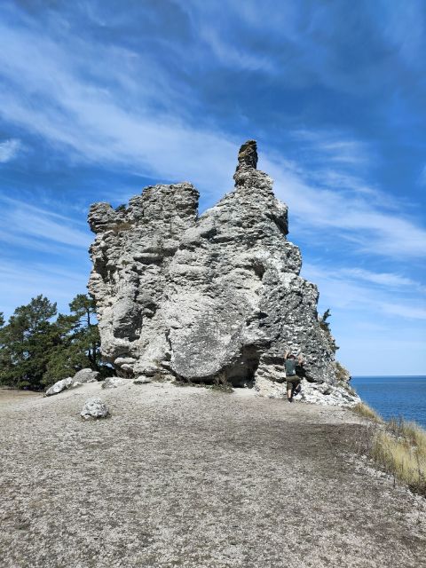 Ein Mann klettern auf einer 10 Meter hohen Kalksteinsäule auf Gotland. 