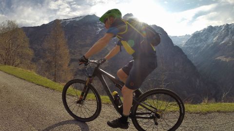 Ein Mountainbiker auf gemütlicher Fahrt mit Aussicht auf die wunderschöne Berglandschaft.