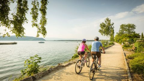 Un couple de cyclistes sur un chemin au bord d'un lac