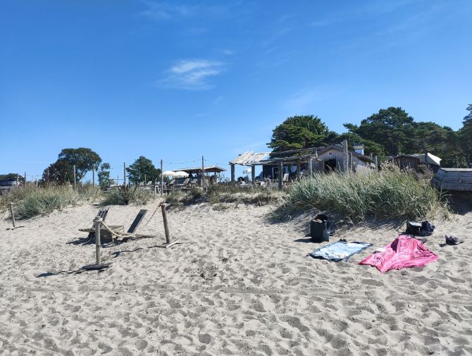 Zwei Badetücher liegen auf weissem Sand am Strand von Tofta. 