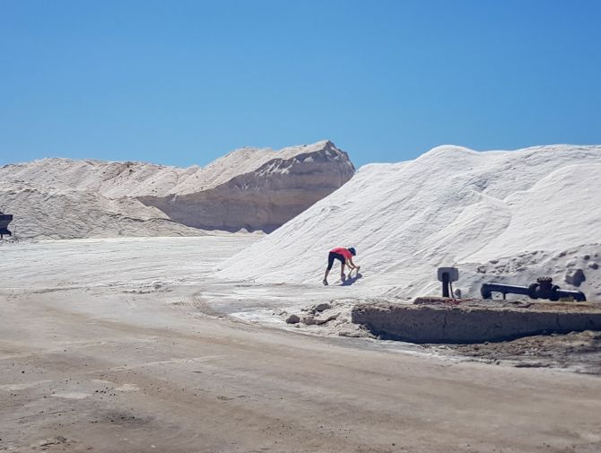 Ein Velofahrer ist bei einem Salzhaufen damit beschäftigt, etwas mitzunehmen.