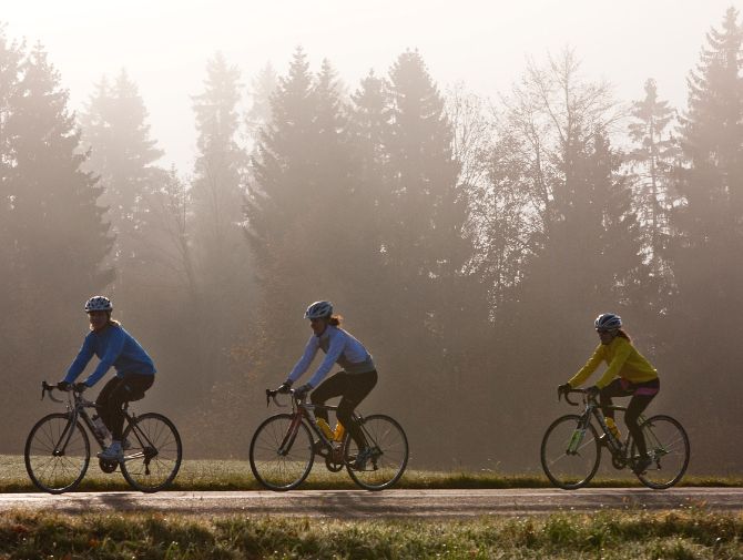 Drei Rennradfahrer fahren hintereinander auf einer Strasse
