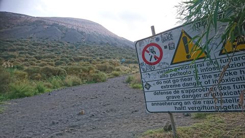 Ein Warnschild warnt vor den Gefahren auf einer Vulkanwanderung.