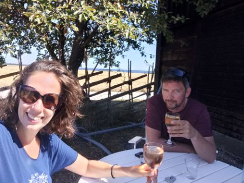 Zwei Personen sitzen mit zwei Gläsern Wein in einem Garten in Gotland. 