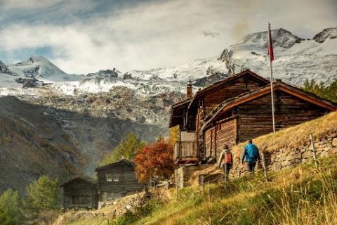 Berghütten in der Nähe von Saas Fee werden von einem Wanderpaar besucht