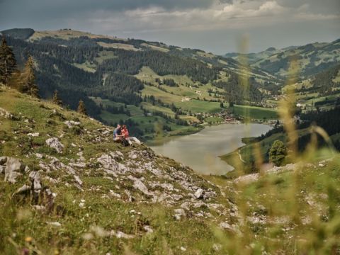 Ein Pärchen macht in Fribourg, oberhalb des Schwarzsees, auf einer steinigen Wiese eine Pause.