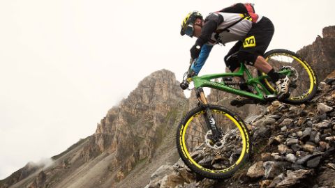 Mutiger Mountainbiker in voller Montur beim steinigen Downhill.