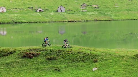 Cyclistes avec un lac en arrière-plan. Le vélo du Gottardo. Vacances à vélo avec Eurotrek.
