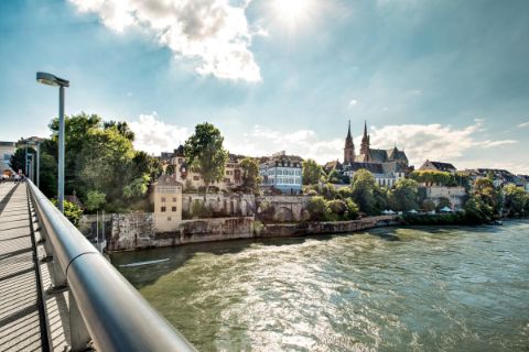 Photo von einer Brücke aus auf das Ufer des Rheins mit Kirche im Hintergrund
