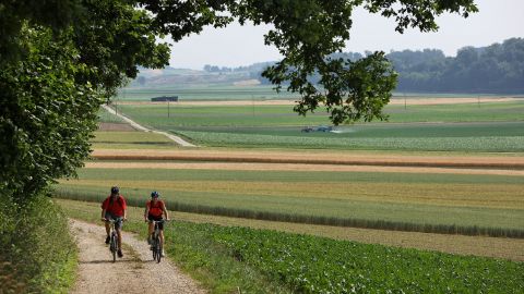 deux cyclistes dans la plaine de Schangnau, le long de la lisière de la forêt