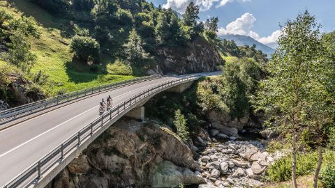 Zwei Rennradfahrer überqueren eine Brücke 
