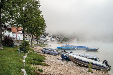 Boote am Ufer des Sees an einem nebeligen Tag