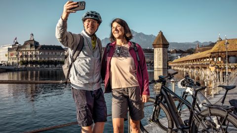 A couple pause for a selfie in front of the Chapel Bridge in Lucerne.
